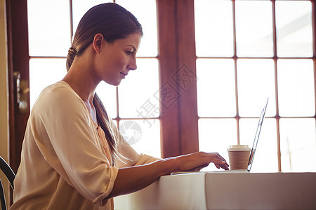 妇女使用笔记本电脑女性餐厅饮料桌子服务器酒店女士客户行业零售背景图片