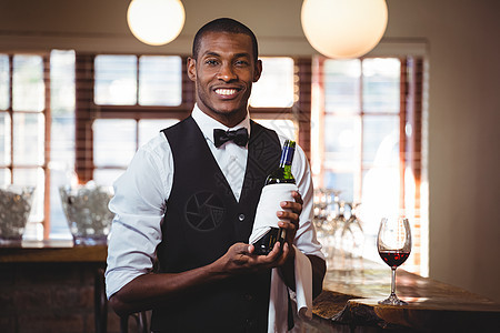 拿着酒瓶的酒保的肖像男性饮料餐厅黑色男人工作酒店服务快乐酒吧图片