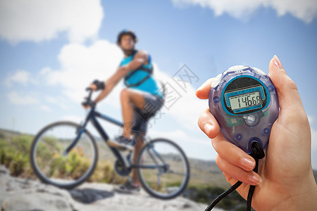 手握定时器的复合图像运动员自行车计时器运动活动冒险闲暇骑术山地荒野图片