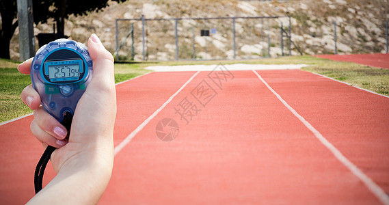 一名持有计时表以衡量业绩的妇女的近身检查速度竞技运动跑步时计双手跑表图片