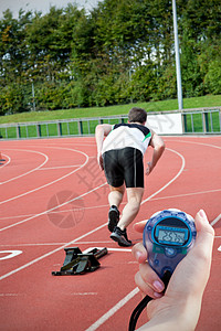 一名持有计时表以衡量性能的妇女的近视图像综合综合图象跑步赛跑者短跑体育场行动锻炼赛马场运动速度愿望图片