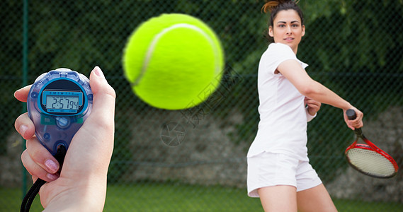 一名持有计时表以衡量性能的妇女的复合图像速度播放器网球运动员球拍时计跑表女性生活方式游戏图片