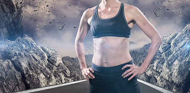 女性运动员的复合形象 手站在臀部上岩石训练线条锻炼双手薄雾黑暗微笑播放器运动服图片