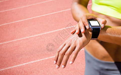 运行的手表身戴连线手表的女运动员被紧贴上综合图像竞赛女性智能短跑手腕移动技术跑步运动设备背景