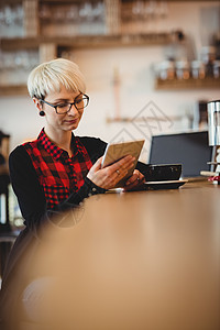在办公室餐厅食堂使用数字石片的年轻妇女工作女性平板服装笔记本触摸屏休闲咖啡服务咖啡店图片