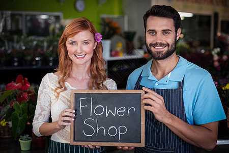 一对夫妇用鲜花店牌子拿着石板的肖像图片