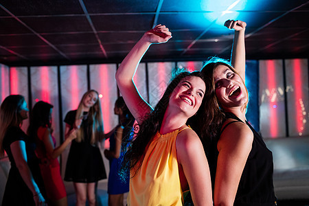 微笑的朋友在舞池跳舞庆典裙子混血社交奢华酒吧餐厅闲暇女性乐趣图片