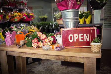 在木制桌子上打开标牌标志招牌中心花园花艺植物零售店铺花瓶丝带图片