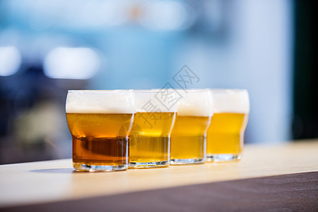 柜台上的啤酒杯贴上食品啤酒取样托盘商业零售夜生活泡沫玻璃饮料图片
