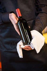 拿着一瓶红酒的服务员行业服务制服瓶子男人食品职员餐巾工作酒店图片