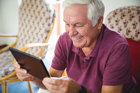 高级男子使用数字平板电脑男性老年微笑药片医学老年人卫生闲暇庇护所男人图片