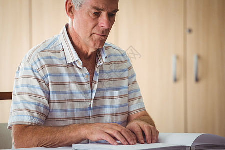 高年男子使用盲文阅读住宅庇护所医学男人闲暇男性疗养院病人退休医疗图片