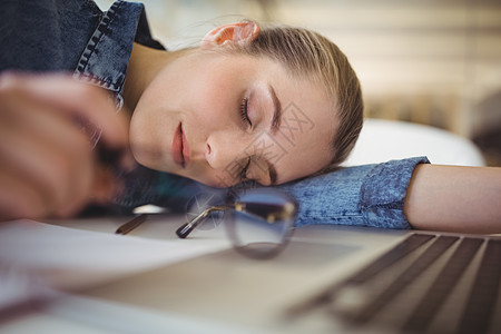 在创意办公室办公桌上午睡的疲累商业妇女公司笔记本电脑工作眼镜人士桌子午睡生意睡眠图片