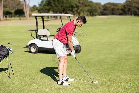 年轻人打高尔夫球的侧面观图片