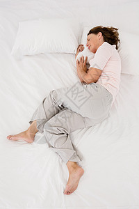 成年妇女睡在床上的高角度视角图片