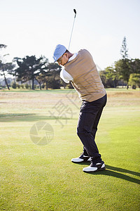 运动员打高尔夫的侧面观男性俱乐部休闲专注天空蓝色服装运动爱好高尔夫球图片