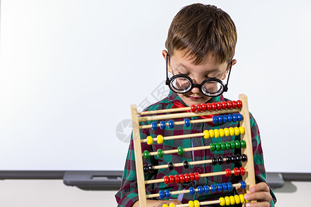 在课堂上玩算盘的可爱男孩小学班级男生瞳孔小学生教育数学知识倾斜童年图片