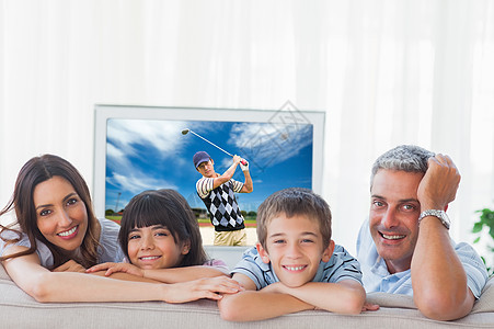 客厅家庭在镜头下微笑的复合形象快乐儿子家庭生活长椅运动员沙发女性电视孩子播放器图片