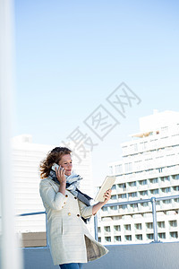 妇女使用数字平板电脑结构休息建筑学手机天空城市生活女性围巾闲暇栏杆图片