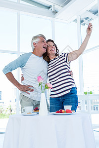 快乐的情侣自拍闲暇团结咖啡店男人幸福老年夫妻手机食物花瓶图片