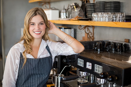 微笑的女服务员做咖啡的肖像职业女士服务围裙准备牛奶餐厅工作水罐工人图片