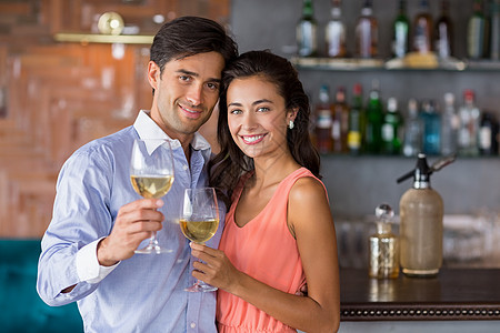年轻夫妇拿着酒杯的肖像快乐微笑男人酒店男性餐厅闲暇酒吧庆典休闲图片