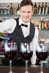 服务员把酒倒进杯子行业咖啡店工作饮料服务玻璃酒吧马甲快乐商业图片