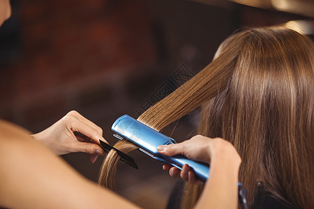 女理发员理理理客户的头发梳子美容师护理女士工作美发指导商业女性梳理图片