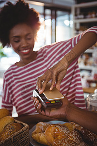 使用nfc技术的智能手机支付账单的妇女钱包托盘工作亲密感零售感情服务桌子别针柜台图片