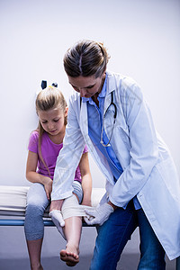 医生给受伤的病人腿上涂绷带疼痛医院事故包扎石膏治疗童年损害休闲病床图片