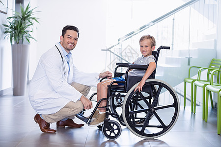 微笑的医生和残疾男孩的肖像病人医务室机动性等候男人男生男性医院职业专家图片