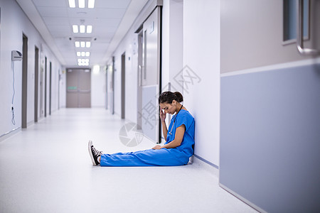 走廊上坐着的有名女医生磨砂膏医院医疗医师悲伤女士职场服务紧张卫生图片