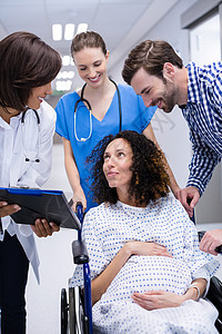 医生在走廊与孕妇互动工作腹部感情卫生女性快乐外套磨砂膏服务住院图片