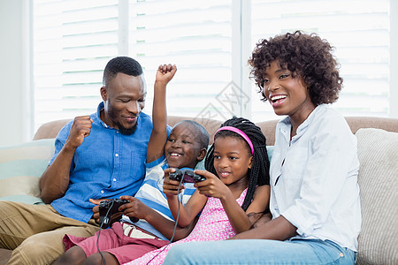 快乐家庭玩游戏游戏休闲互动男人喜悦控制沙发父亲家庭生活客厅男生图片