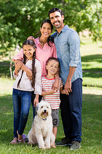 快乐家庭的肖像 他们的宠狗站在公园里闲暇生活旅行团结亲热动物母亲男人混血野餐图片