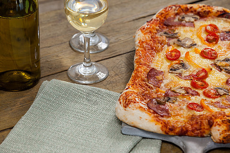 好吃的比萨饼在披萨盘上配着一杯酒瓶和红酒现实感情食物板布浇头饮食草本植物酒精小吃辣椒图片