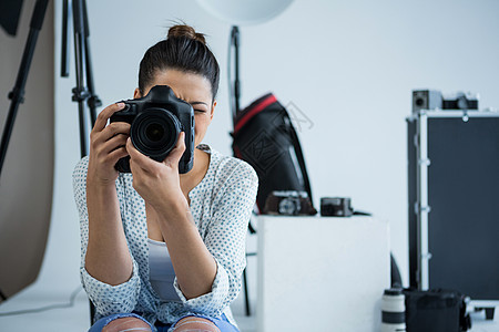 配备数码相机的女摄影师生活单反快照职业摄影混血专注商业工作室活力图片