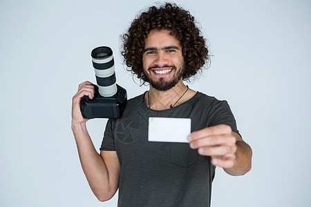 男摄影师在演播室显示访问卡商业微笑相机男性服装工作室职业快乐男人摄影图片