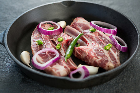 烤锅中的刀片和切碎的辣椒和洋葱美食生肉黄瓜红肉寒冷黑色木板平底锅食谱柠檬图片