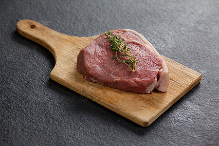 木板上的Sirloin切纸美食点缀红色烹饪草本植物牛肉红肉洋葱食谱生肉图片