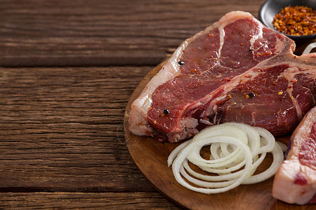 木制圆盘上的刀片 洋葱和香料食谱味道生肉红肉牛肉营养黑色圆形美食木头图片