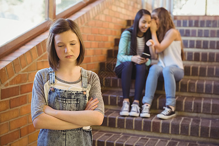 学校朋友在学校走廊欺凌一个可悲女孩孩子休闲混血知识门厅同学双臂悲伤耳语中学图片
