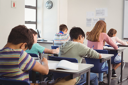 在课堂上做功课的幼儿园学生女孩笔记本青少年男生专注青春期休闲教育家庭学校图片