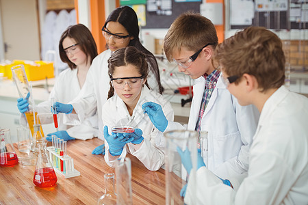 细心的学童在实验室做化学实验男生试验桌子孩子友谊知识教育化工防护眼镜橙子图片