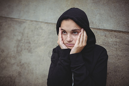 身着黑色戴黑头罩外套的令人厌恶的少女 手对面站立不动图片