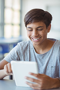 快乐的男孩在课堂上使用数字平板电脑学生青年网络滚动阅读青春期男生技术中学服装图片