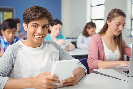 学生在课堂上使用数字平板电脑和笔记本电脑的学生技术青少年中学女学生混血教育服装男性功课女性图片