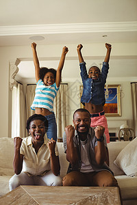 父母和孩子在客厅看电视时玩得开心乐趣生活男性儿子沙发女孩女儿男人母亲父亲图片