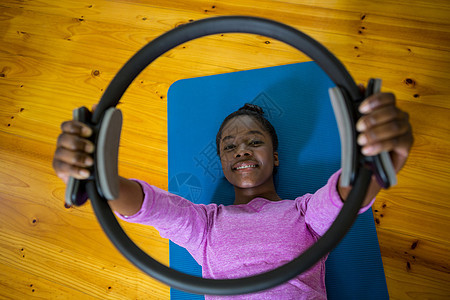 微笑合身的女士在垫子上用枕边环打运动生活训练练习专注运动服身体运动垫现实体质体操图片