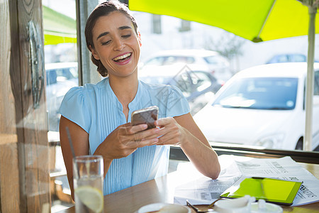 咖啡馆使用移动电话的女执行官快乐人士休闲装桌子生活杯子报纸餐厅饮料职业图片